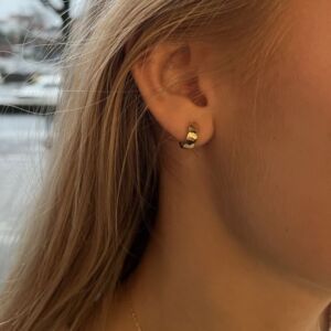 Øreringer brede i gult gull. Diameter 12 mm Bredde 4,3 mm, vist på modell