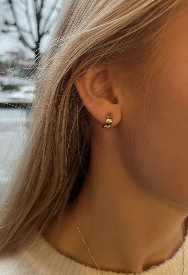 Øreringer brede i gult gull. Diameter 12 mm Bredde 4,3 mm, vist på modell