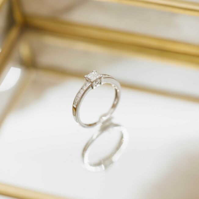 Elegant ring i hvitt gull med 4 litt større prinsesseslipte diamanter i midten og mange små på siden.