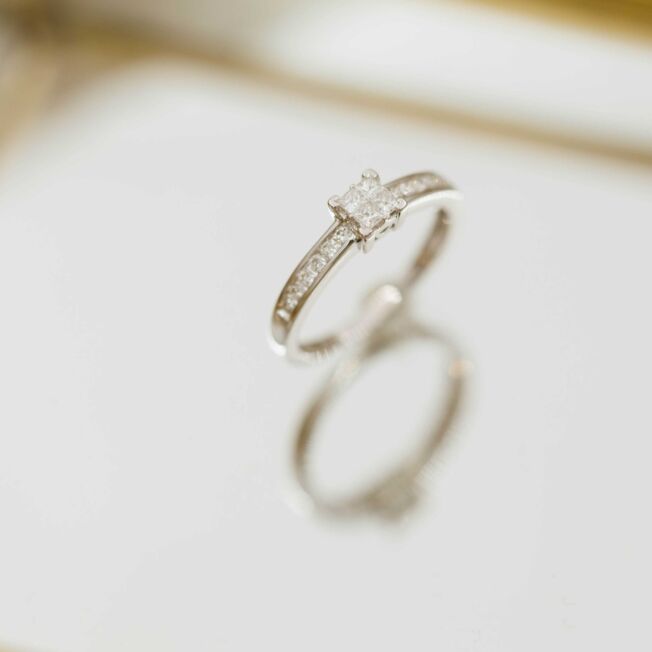 Elegant ring i hvitt gull med 4 litt større prinsesseslipte diamanter i midten og mange små på siden.
