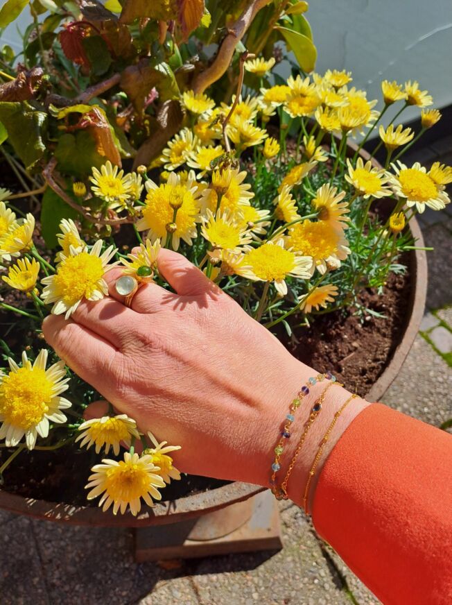 Armbånd i forgylt sølv med 3 London blå krystaller i lenken. Vist sammen med andre smykker.