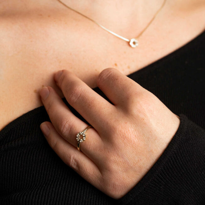 Ring i gult gull med 6 diamanter i en sirkel, hver av diamantene er fattet i et lite hjerte.