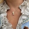 Ørepynt liten blomst i gult gull med diamanter og ferskvannsperle