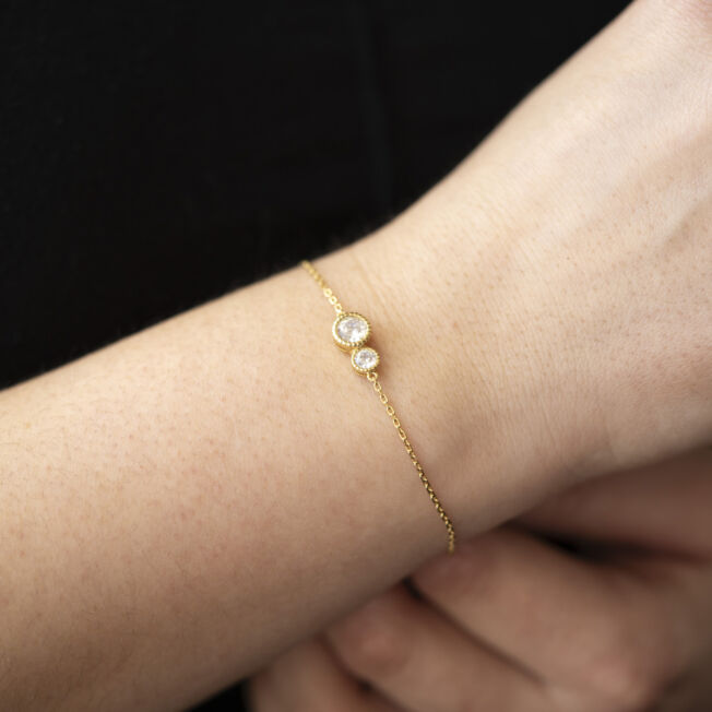 Armbånd fra Nora Mørk by Gulldia. Forgylt sølv med 2 c.zirkonia i ulik størrelse.
