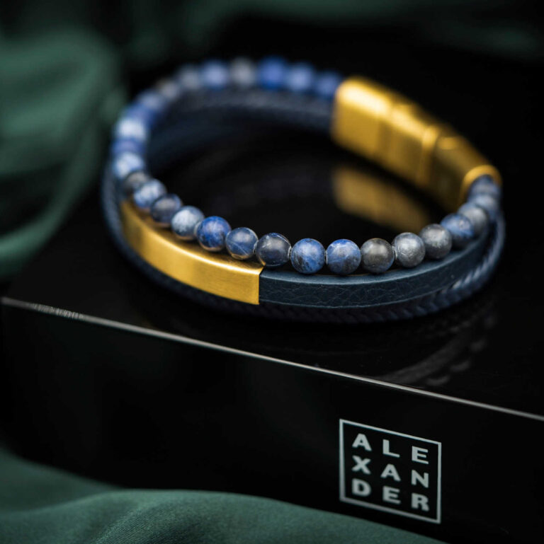 Armbånd i gullfarget stål, blått skinn og sten
