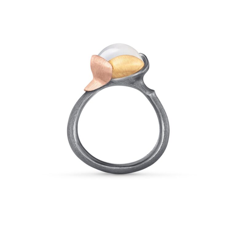 Lotus ring i mix av sølv og gull. I midten er det fattet en hvit cabochonslipt månesten, fra Ole Lynggaard