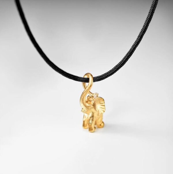 Den minste elefanten fra Ole Lynggaard i gult gull, med diamant i snablen., på sort snor som armbånd