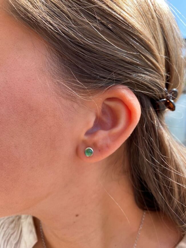Lotus ørepynt i sølv, med cabochonslipt grønn serpentin. Fra Ole Lynggaard i København. 6 mm i diameter