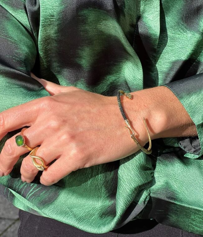 Snake armring i gult gull sammen med andre smykker fra Ole Lynggaard
