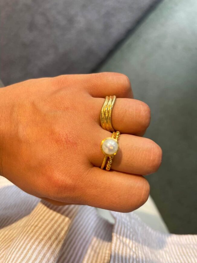 Ring i forgylt sølv med ferskvannsperle, vist sammen med andre ringer.