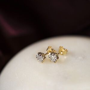 Ørepynt i gull med diamanter fattet som en illusjon. Gir inntrykk av å være en stor sten.