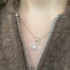 EC 1914 Anheng "Swirl" i gult gull med diamant og perle