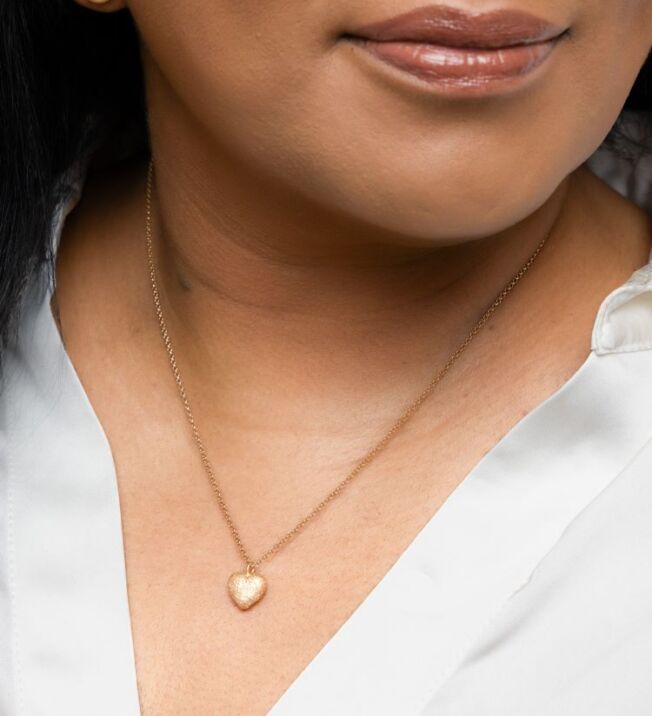 Ella´s heart Anheng i 925 forgylt sølv formet som et hjerte. Den ene siden er blank og den andre er børstet med stardust overflate. Stardust referer til overflaten. En nesten diamantlignende struktur som gjør at det glitrer ekstra fint.