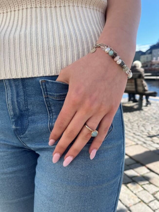 Armbånd og ring fra By Birdie i oksidert sølv med blå toner. I ringen er det sølv og gull med rund akvamarin