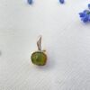 5090364d- miljø Grace anheng fra By Birdie med Raw Peridot. En uslipt peridot fattet i sølv, med gult gull kule