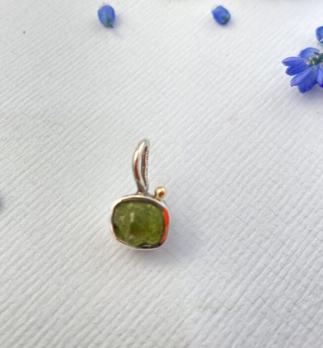5090364d- miljø Grace anheng fra By Birdie med Raw Peridot. En uslipt peridot fattet i sølv, med gult gull kule