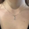 Anheng i hvitt gull med evighetstegn. PÅ den ene buen er det fattet små diamanter. Her er det på halsen til en modell.