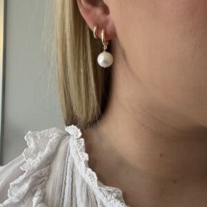 Ørering i gult gull med en ferskvannsperle. Henger fint fra øret