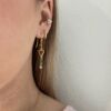Ørepynt i 925 forgylt sølv som henger fra en krok. I lenken er det et åpent hjerte, grønn agat, amasonitt og peridot. Fra Susanne Friis Bjørner