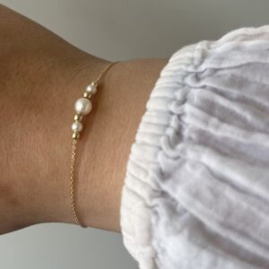 Armbånd tynt i gult gull med 3 ferskvannsperler og gullkuler i lenke.