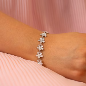 Armbånd i rhodinert sølv med stardust overflate. Små blomster med c.zirkonia i midten. 10 mm i diameter