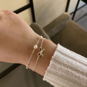 Armbånd i sølv med sløyfe symbol.