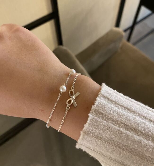 Armbånd i sølv med sløyfe symbol.