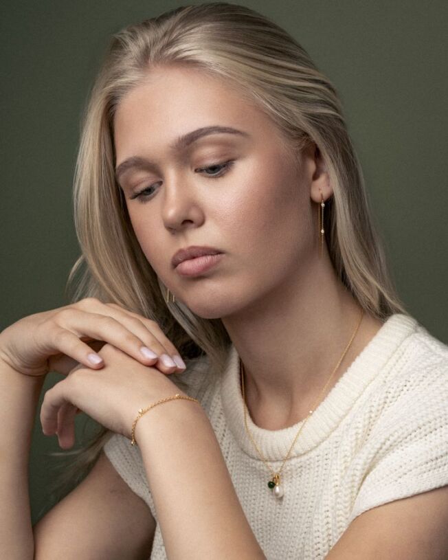 Grace ørepynt og armbånd i forgylt sølv med c.zirkonia. Rundt halsen kjede Fina med Little Prime og Afrodite anheng med perle.
