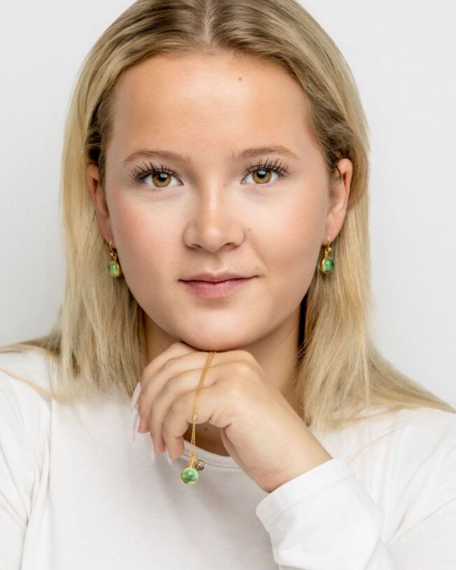 Anheng og ørepynt fra Julie Sandlau med grønn ametyst-farget krystall og LIttle Prime med røkfarget krystall anheng i forgylt sølv