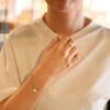 Blomsterserien til EC 1914 laget i Sandnes gult gull. Enkelt armbånd med åpne ringer med avtagbar blomstercharms med diamant i midten.