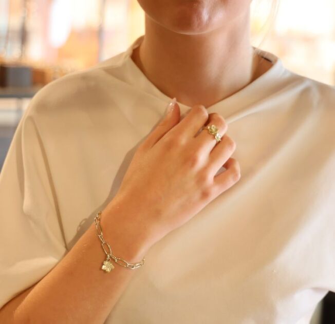Blomsterserien til EC 1914 laget i Sandnes gult gull. Enkelt armbånd med åpne ringer med avtagbar blomstercharms med diamant i midten.