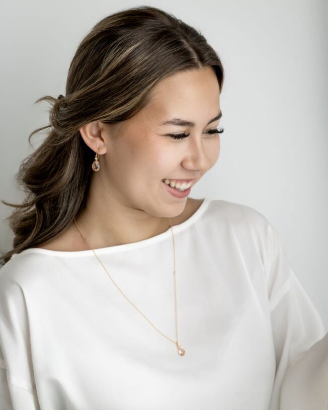 Ofelia ørepynt i forgylt sølv med krystall som er fasettslipt i en krok med en oval c.zirkonia som er fattet over. Fargen kalles Peach, Ferskenfarget. I tillegg anheng på kjede med krystall.