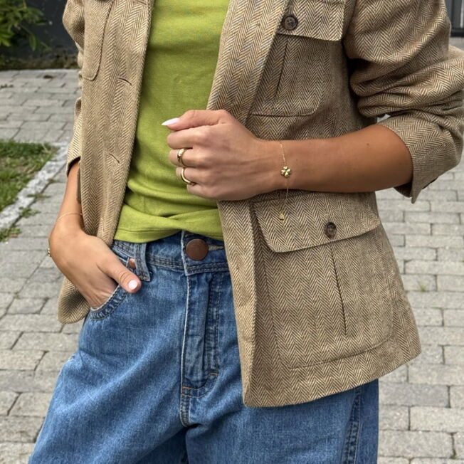 Lucky armbånd med firkløver midt i lenken. Regulerbar lengde i gullfarget stål fra Frida Leonore