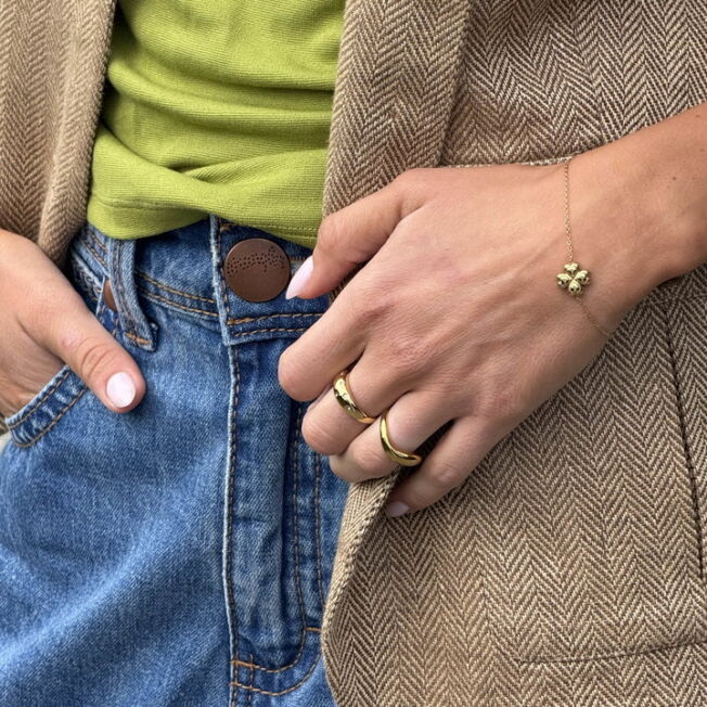 Lucky armbånd med firkløver midt i lenken. Regulerbar lengde i gullfarget stål fra Frida Leonore